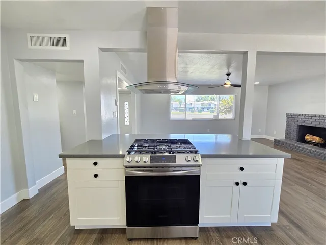 a kitchen with stainless steel appliances a stove and white cabinets