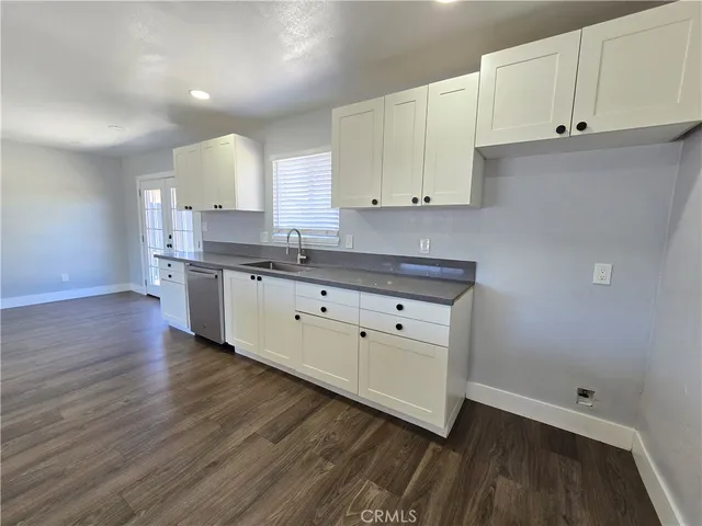 a kitchen with cabinets wooden floor and a sink