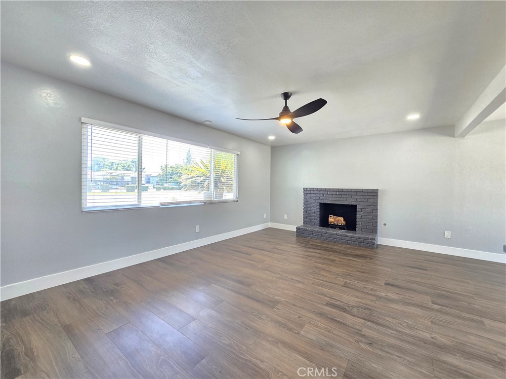 3404 Planz Road Bakersfield, CA 93309 - Photo 10 of 23 an empty room with windows fireplace and wooden floor