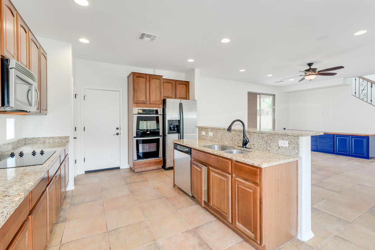 1074 South Hawk Lane Gilbert, AZ 85296 - Photo 12 of 35 a large kitchen with stainless steel appliances granite countertop a sink and cabinets