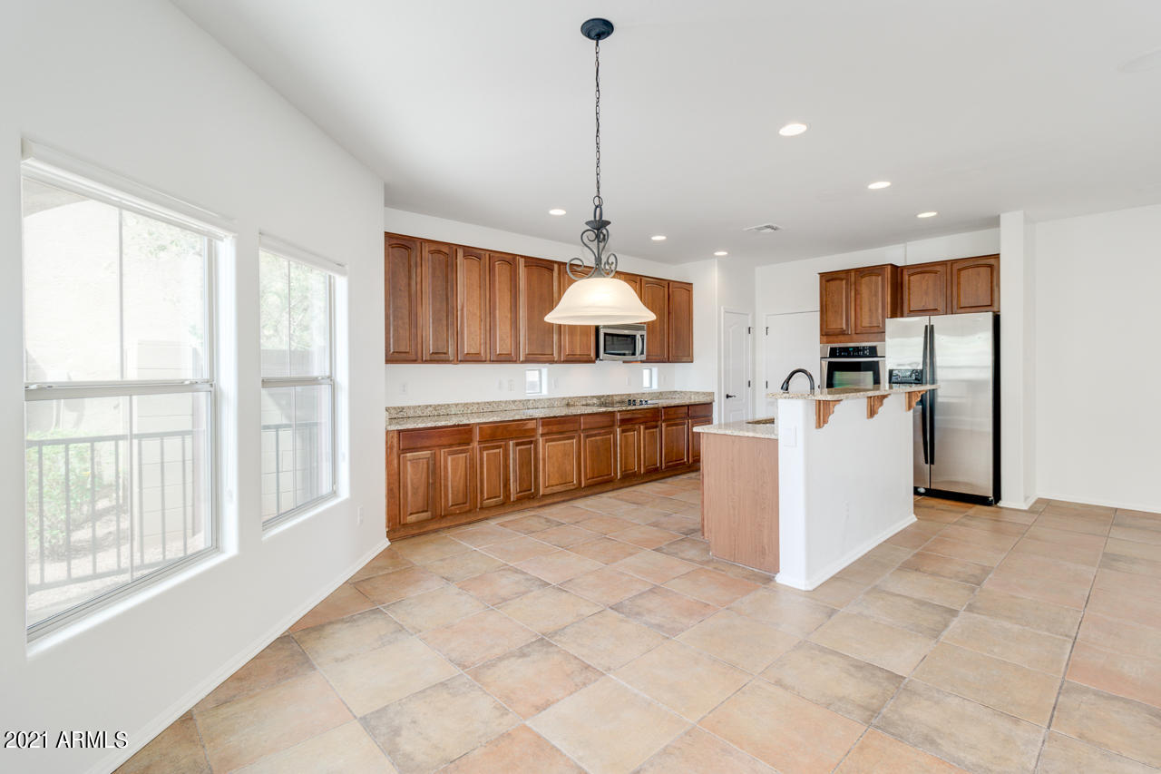 1074 South Hawk Lane Gilbert, AZ 85296 - Photo 15 of 35 a large kitchen with kitchen island a large counter top stainless steel appliances and cabinets