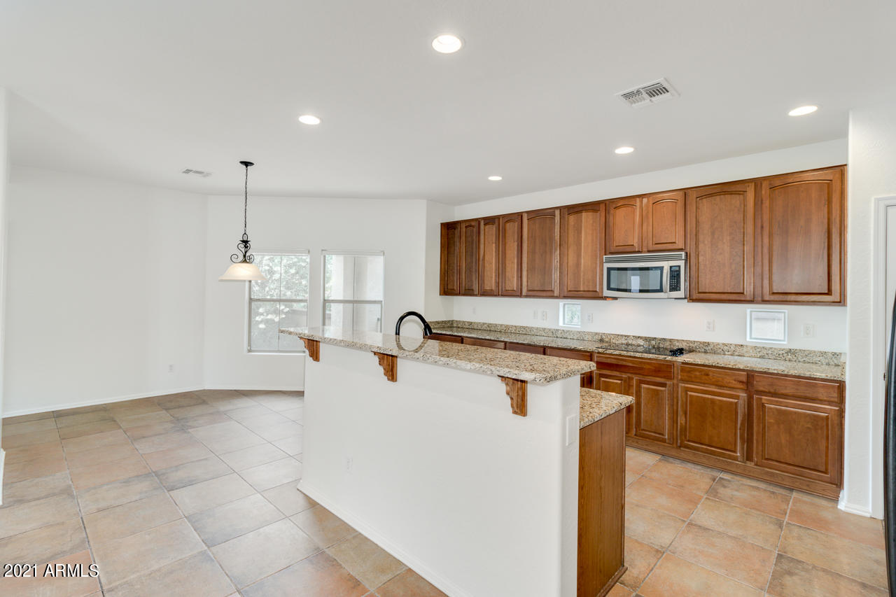 1074 South Hawk Lane Gilbert, AZ 85296 - Photo 10 of 35 a large kitchen with stainless steel appliances granite countertop a sink and cabinets