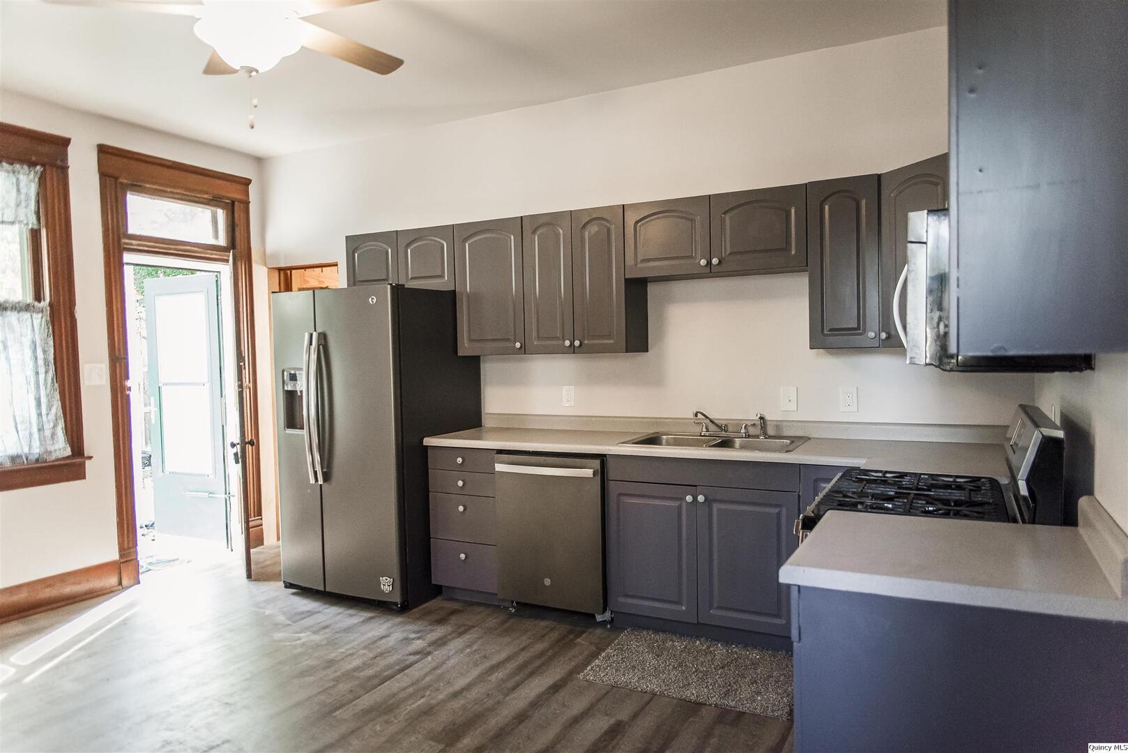 512 Madison Street Quincy, IL 62301 - Photo 11 of 15 a kitchen with stainless steel appliances a refrigerator a sink and wooden cabinets