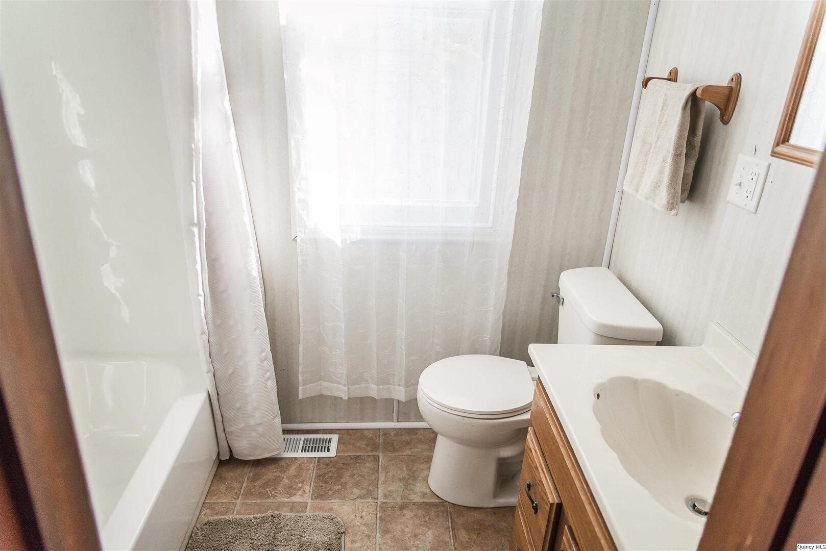 512 Madison Street Quincy, IL 62301 - Photo 12 of 15 a bathroom with a sink and a toilet