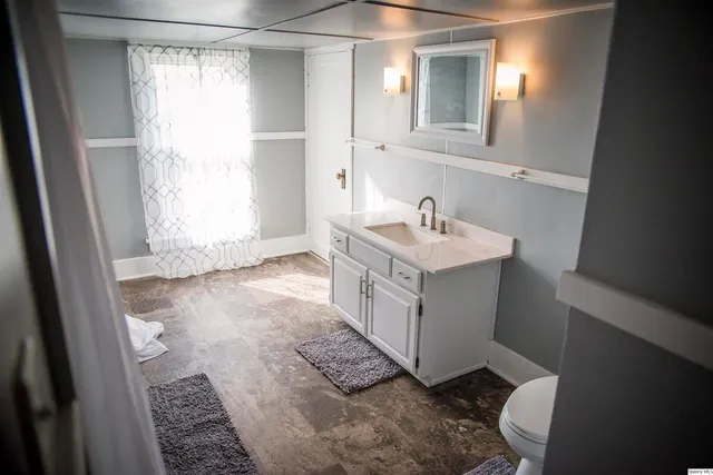 a bathroom with a sink a toilet and a mirror