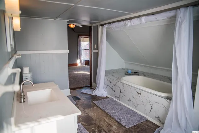 a bathroom with a tub sink and mirror