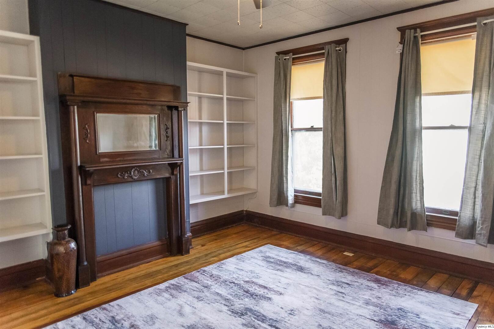 512 Madison Street Quincy, IL 62301 - Photo 7 of 15 a view of an empty room with wooden floor and a window