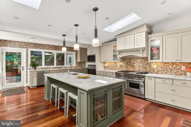 a spacious bathroom with a granite countertop sink a large mirror and a bathtub
