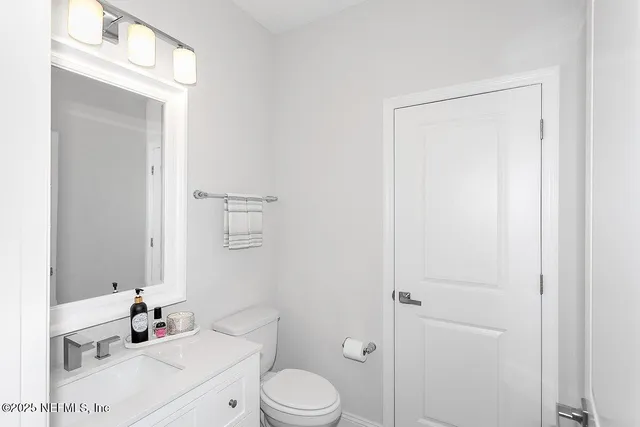 a bathroom with a sink vanity mirror and toilet