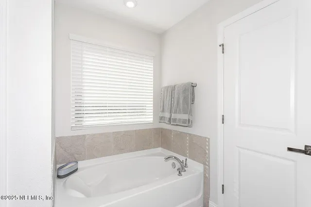a white bath tub sitting next to a window