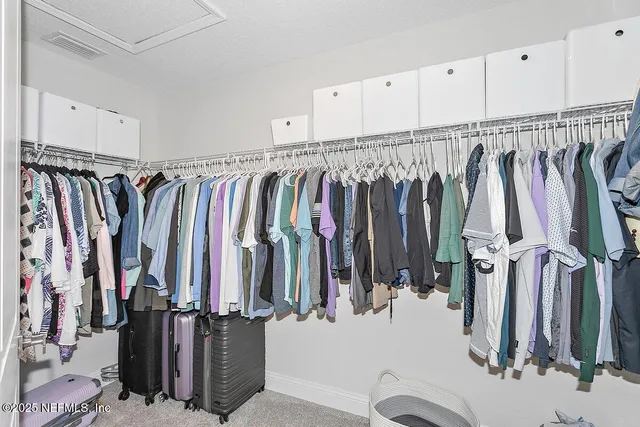 a view of walk in closet with clothes