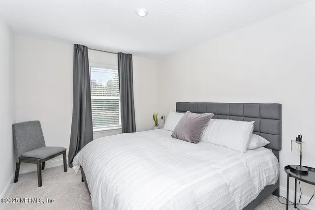 a bedroom with a bed and chair