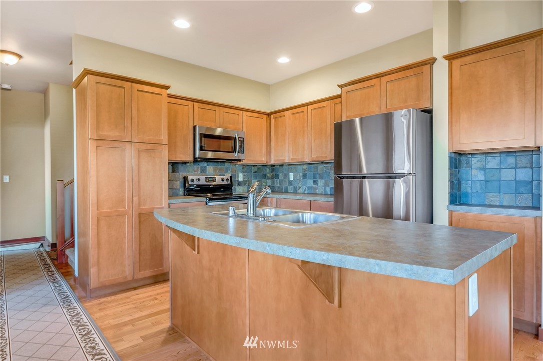 816 Red Maple Loop Everson, WA 98247 - Photo 5 of 22 a kitchen with stainless steel appliances granite countertop a refrigerator a stove a sink a oven with wooden cabinets and wooden floor