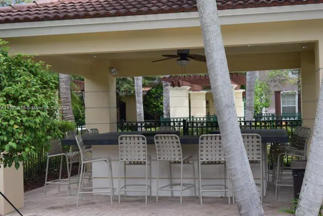 a view of a patio with dining table and chairs with plants