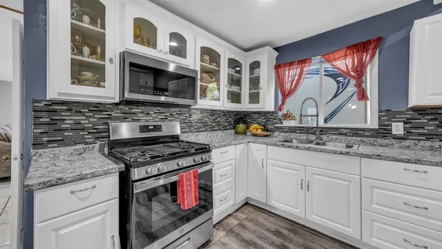 a kitchen with stainless steel appliances granite countertop a stove and a sink
