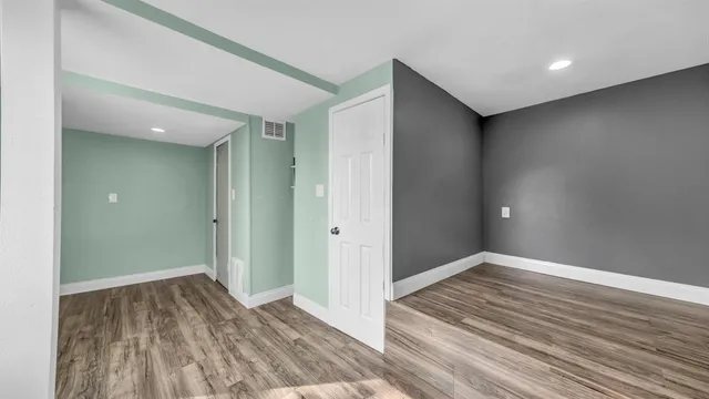 a view of a hallway with wooden floor and staircase