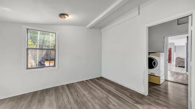 a view of an empty room with wooden floor