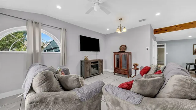 a living room with furniture ceiling fan and a flat screen tv