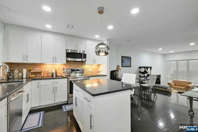 a kitchen with granite countertop a sink counter top space appliances and cabinets