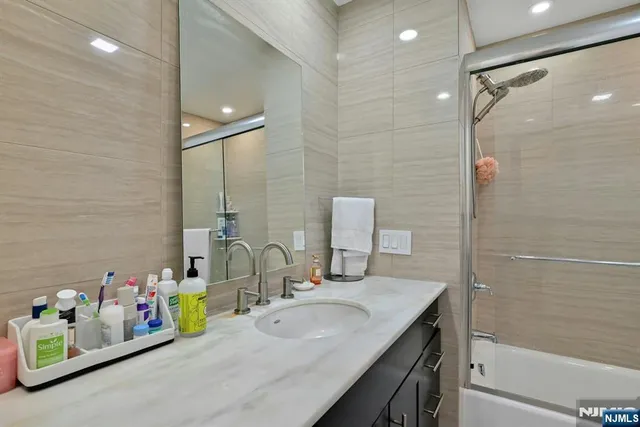 a bathroom with a sink mirror and shower