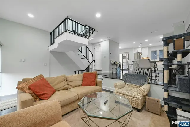 a living room with furniture kitchen view and a wooden floor
