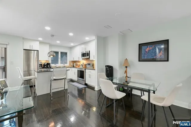 a kitchen with white cabinets and refrigerator