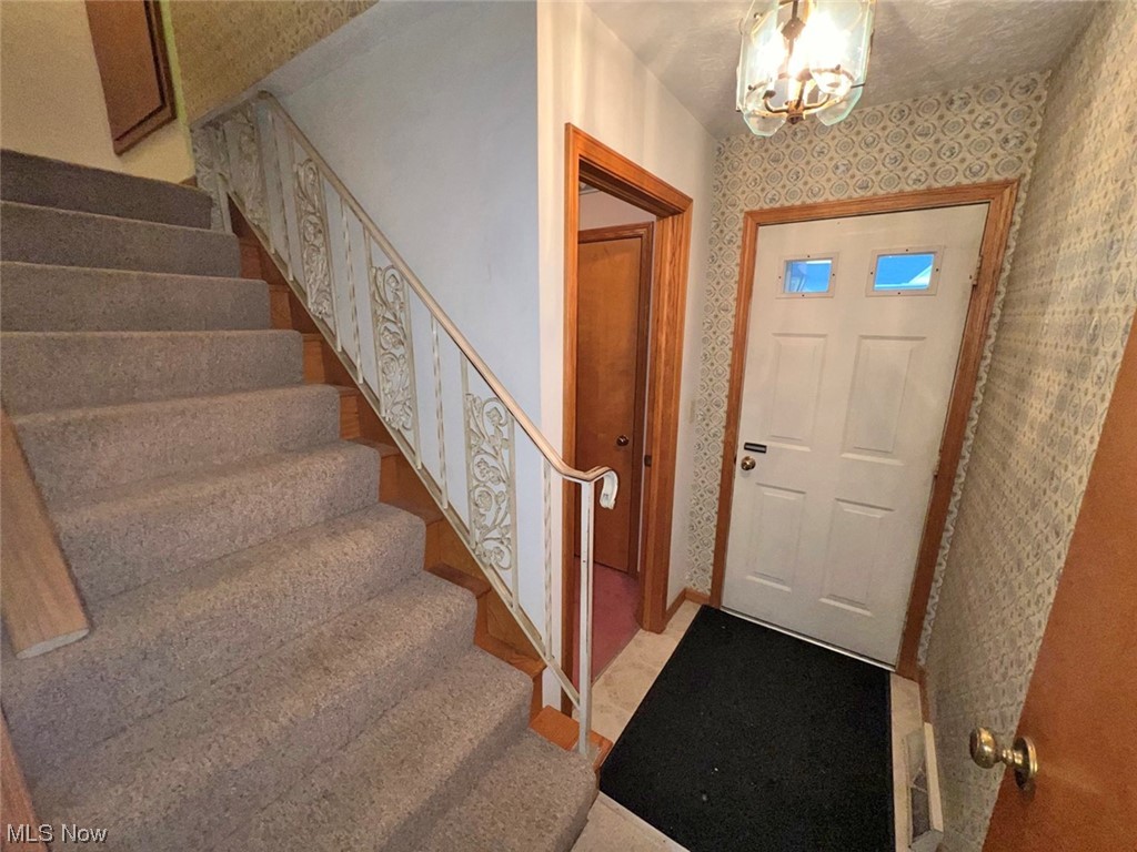918 Amherst Road Northeast Massillon, OH 44646 - Photo 14 of 31 Entryway with light carpet and an inviting chandelier