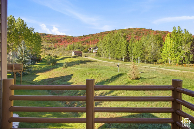 7396 Brook Hollow Loop Road Park City, UT 84098 - Photo 16 of 60 Expansive natural landscape with rolling hills, distant trees displaying autumn foliage, and a rustic log railing