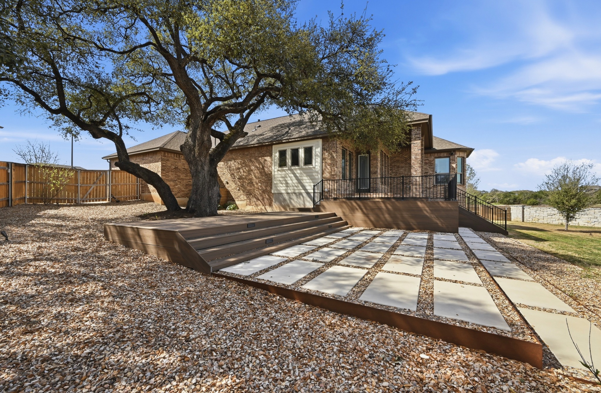 208 West Branch Road Kyle, TX 78640 - Photo 20 of 27 The deck drops down and wraps around a beautiful heritage oak, creating a backyard with real character.