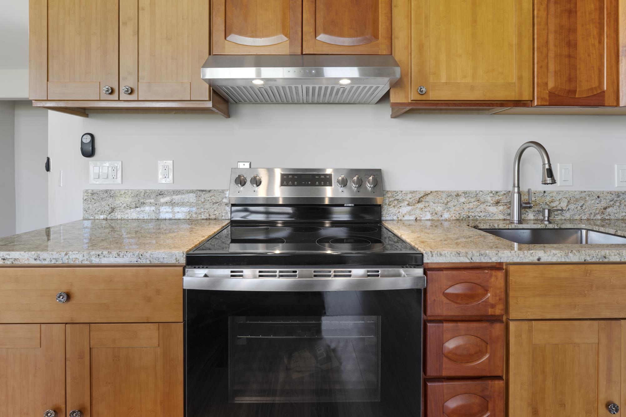 1002 South Kihei Road, Unit 114 Kihei, HI 96753 - Photo 13 of 50 a kitchen with granite countertop stainless steel appliances and cabinets