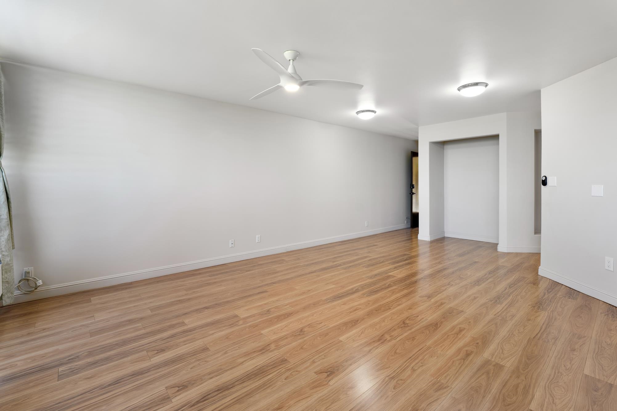 1002 South Kihei Road, Unit 114 Kihei, HI 96753 - Photo 18 of 50 a view of an empty room with wooden floor and a ceiling fan