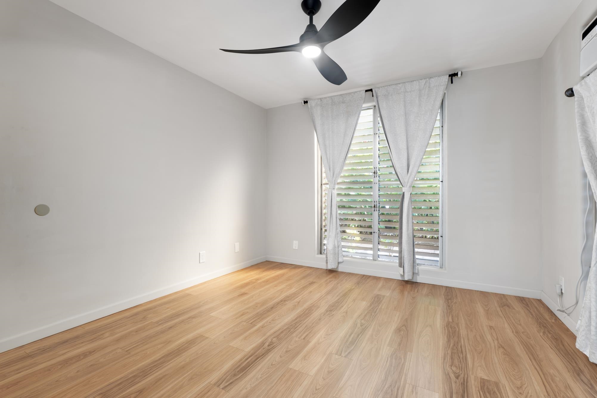 1002 South Kihei Road, Unit 114 Kihei, HI 96753 - Photo 20 of 50 a view of an empty room with wooden floor and a window