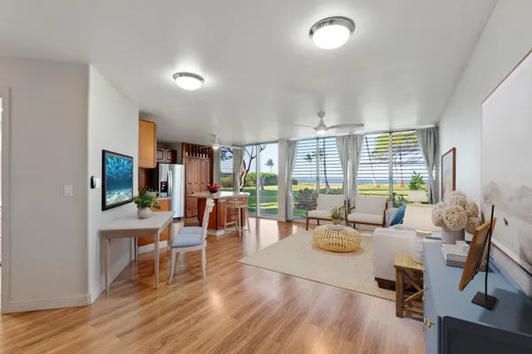 a living room with furniture large window and wooden floor