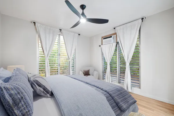 a bedroom with a bed and a large window