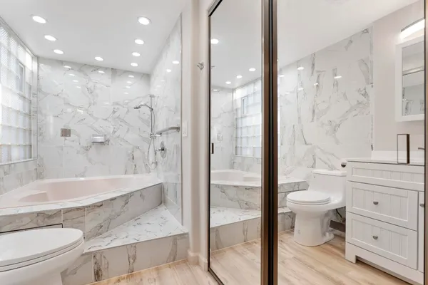 a bathroom with a sink a toilet and shower