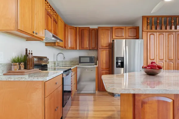 a kitchen with stainless steel appliances granite countertop a sink a refrigerator and cabinets