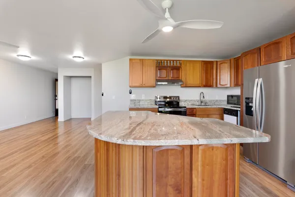 a kitchen with stainless steel appliances granite countertop a sink refrigerator and microwave