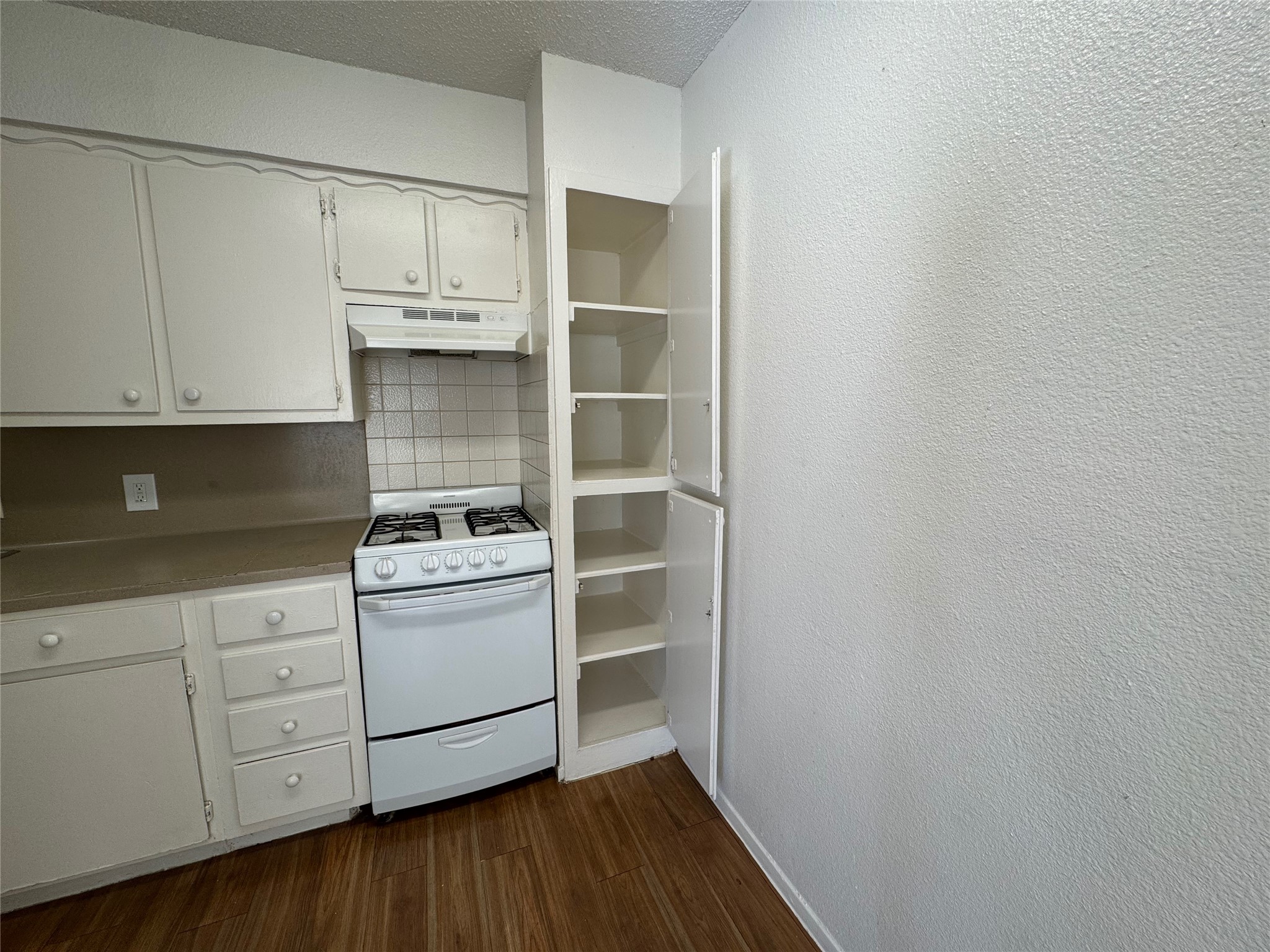 4810 West Wind Trail, Unit 104 Austin, TX 78745 - Photo 7 of 21 a kitchen with granite countertop white cabinets and white appliances