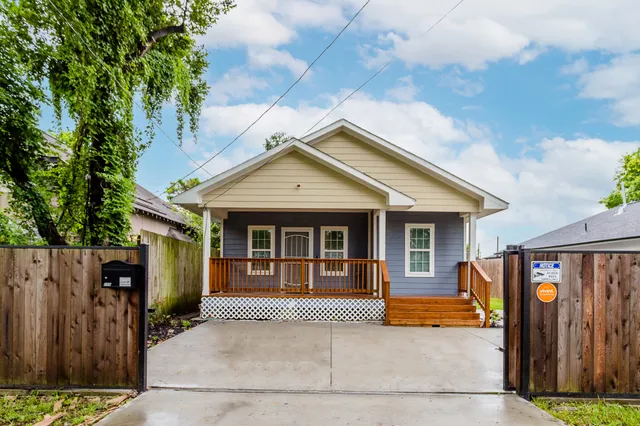 a view of a house with wooden walls and a yard