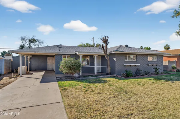 a front view of a house with a yard and potted plants