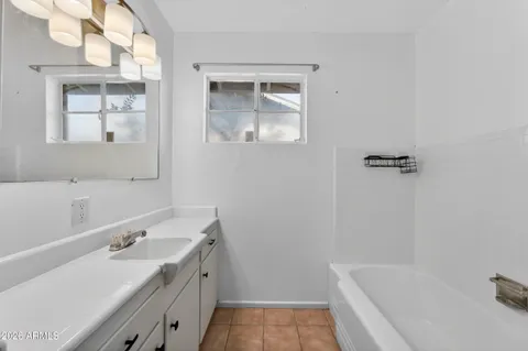 a bathroom with a tub a sink and mirror
