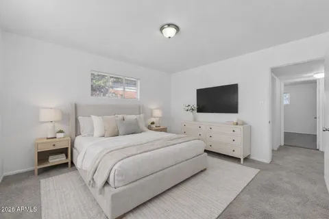 a bedroom with bed tv and window