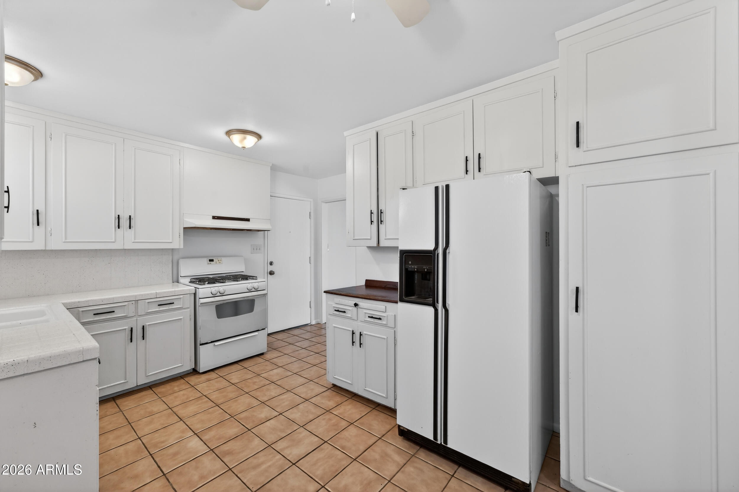 2233 West Flower Street Phoenix, AZ 85015 - Photo 7 of 36 a kitchen with white cabinets and white appliances