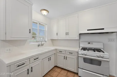 a kitchen with cabinets appliances a sink and a counter top