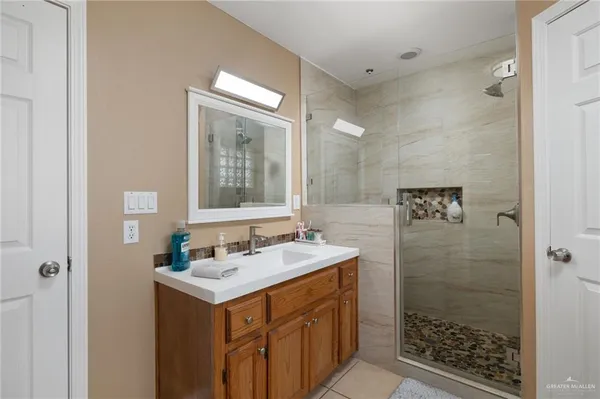 a bathroom with a shower sink and mirror
