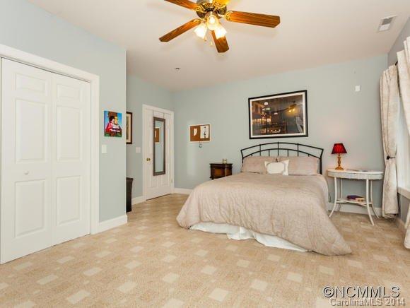 182 Flying Hawk Road Waynesville, NC 28786 - Photo 15 of 24 a bedroom with a bed and a chandelier