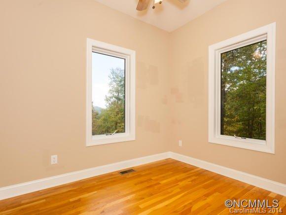 182 Flying Hawk Road Waynesville, NC 28786 - Photo 19 of 24 a view of an empty room with wooden floor and a window