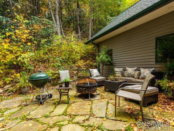 182 Flying Hawk Road Waynesville, NC 28786 - Photo 5 of 24 a view of a patio with table and chairs with wooden floor and fence