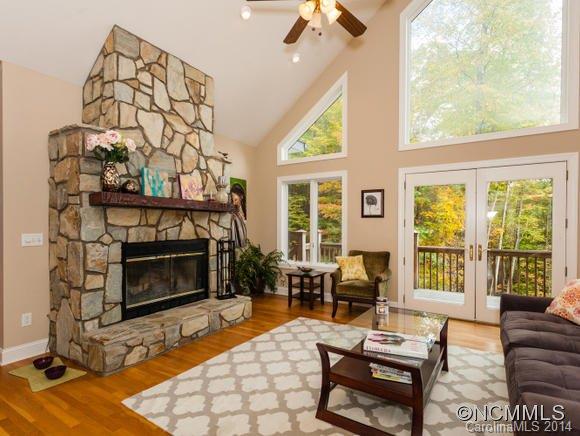 182 Flying Hawk Road Waynesville, NC 28786 - Photo 9 of 24 a living room with furniture a fireplace and a floor to ceiling window
