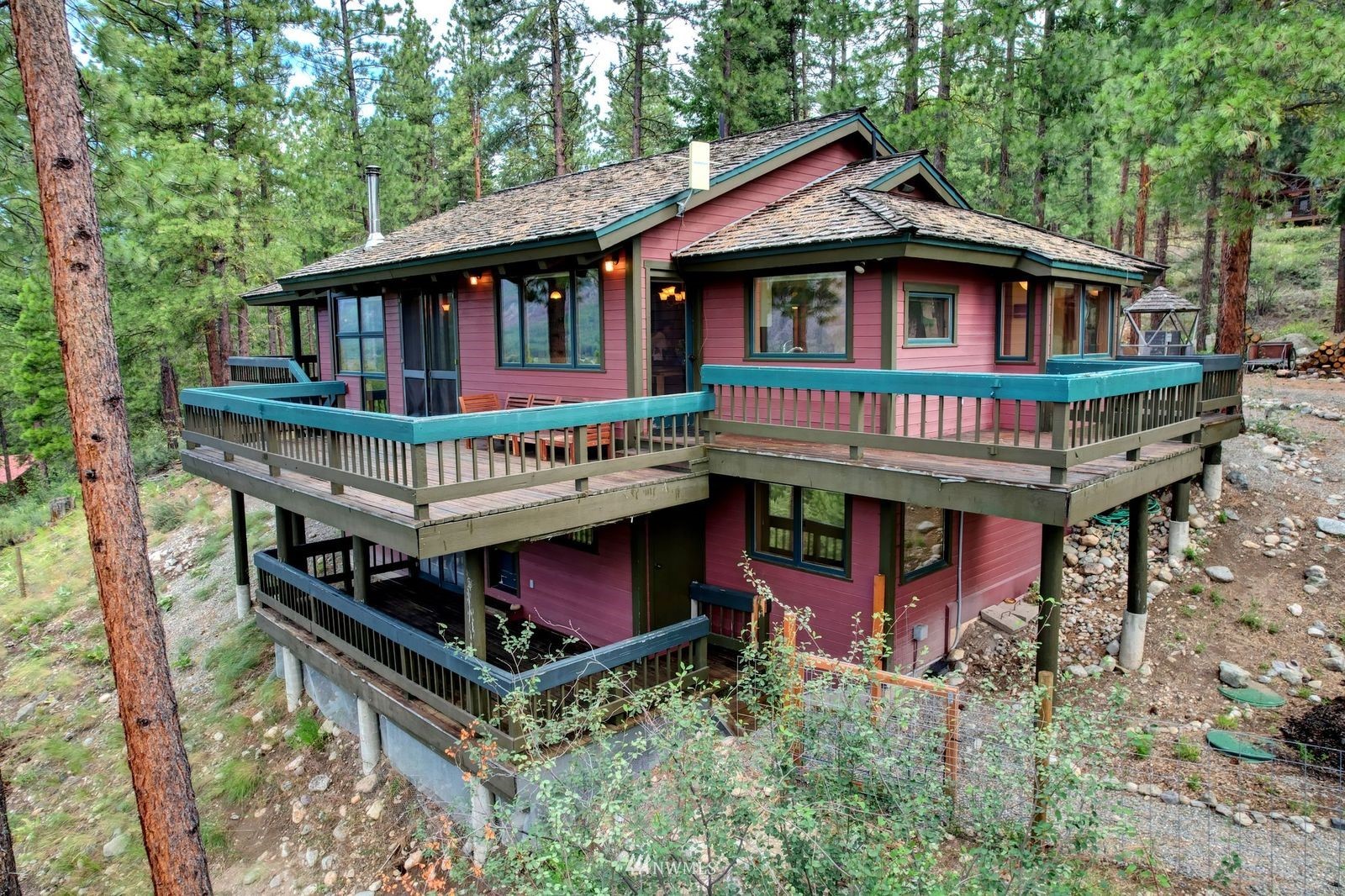17 Cassal Road Winthrop, WA 98862 - Photo 6 of 28 a view of a house with large windows and a table and chairs